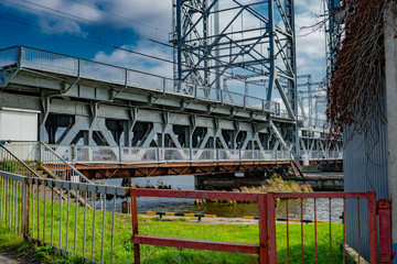 iron trestle drawbridge stands over the river against the blue sky