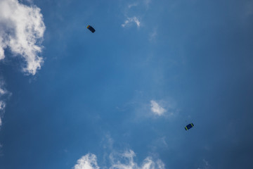 Parachute jumpers on blue sky