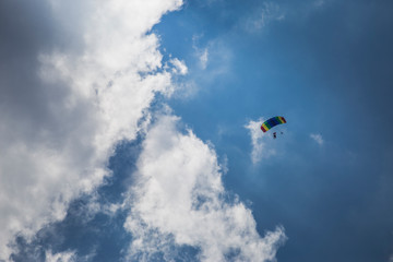 Parachute jumper in front of clouds