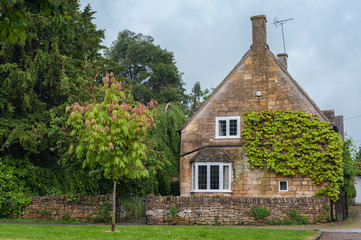 BROADWAY, ENGLAND - MAY, 27 2018: Pretty Cottages with climbing plants in the village of Broadway, in the English county of Worcestershire, Cotswolds, UK 