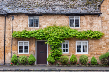 BROADWAY, ENGLAND - MAY, 27 2018: Pretty Cottages with climbing plants in the village of Broadway, in the English county of Worcestershire, Cotswolds, UK 