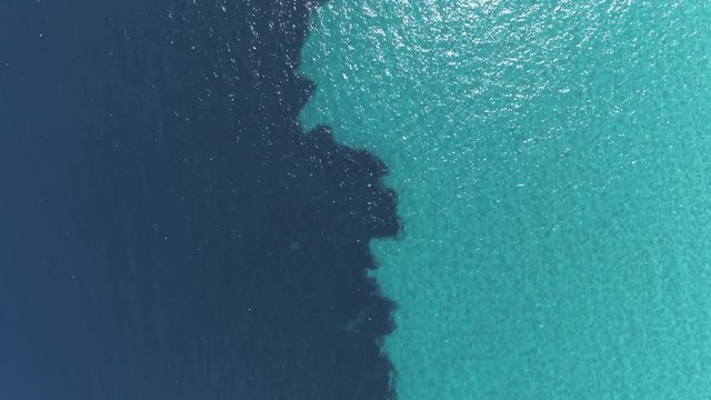 Aerial top down view. Calm clear blue sea water background. 4K
