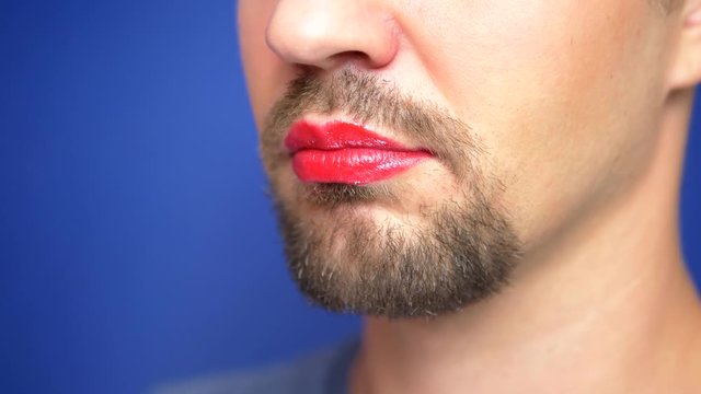 close-up. Bearded man with painted lips kisses a white rat