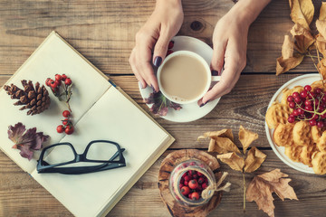 Woman hands holding a cup of coffee with milk and halloween  cookie