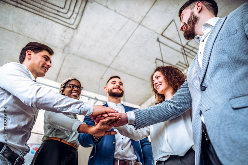 Wall mural teamwork. young business people showing unity with their hands together. business concept.