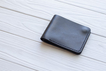 black leather wallet on a wooden background