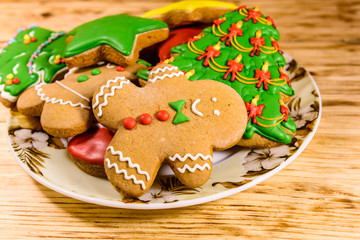 Plate with different christmas gingerbread cookies on wooden table