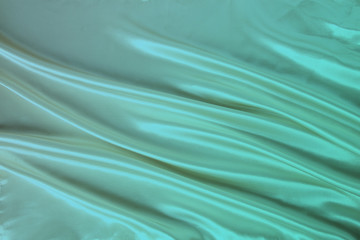 Obraz premium soft folds on delicate green shiny silk, luxury concept, background for the designer, horizontal, close-up, copy space