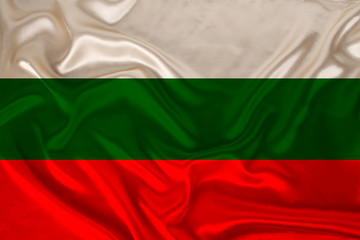 photo of the national flag of Bulgaria on a luxurious texture of satin, silk with waves, folds and highlights, closeup, copy space, concept of travel, economy and state policy, illustration
