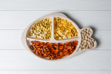 Various pills in a fish-shaped plate