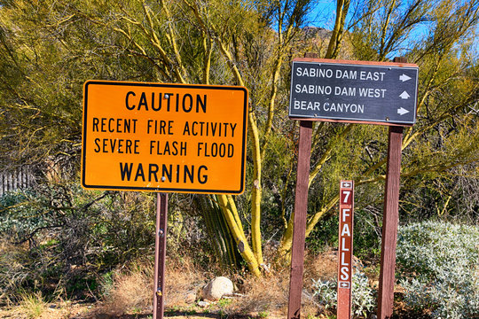 Caution sign severe flash flood warning and direction sign in the Sabino Canyon National Forest, Tucson AZ