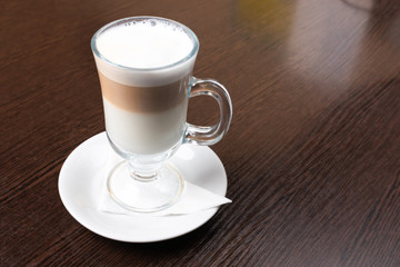 Mug of latte, on a dark, wooden background.