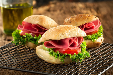 Healthy eating bagel sandwich for breakfast with salami ham, tomatoes and lettuce