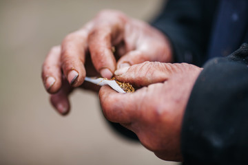 Making cigarettes by wrapping tobacco by hand and Making cigarettes by wrapping tobacco by hand and Passive smoking concept. a lot of smoke  