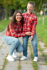 Fototapeta premium Mom and son are smiling happily on a walk in the park.