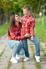 Fototapeta premium Mom and son are smiling happily on a walk in the park.
