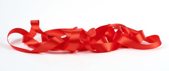 curled red satin ribbon on white background, festive backdrop
