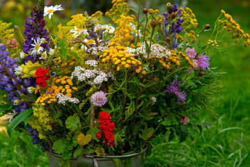 Bright autumn bouquet of wild and garden flowers on a background of green grass.