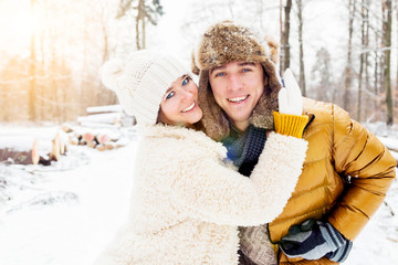 glückliches junges Paar, die zusammen Zeit im Winterwald verbringt