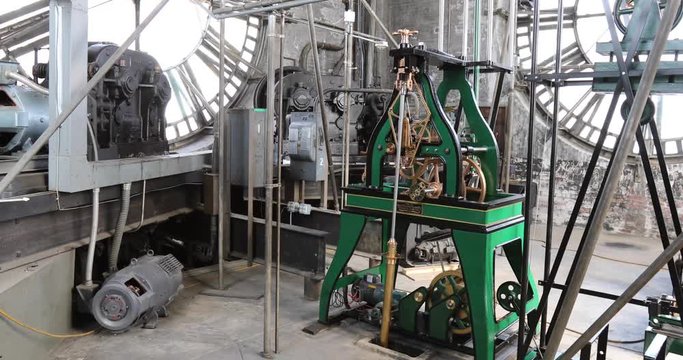 Vintage gravity driven clock tower mechanisms and dials inside tower with sound.