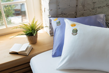 the book on the windowsill. the book o bed in hotel room. sofa in living room. Bedroom with Windows. Flowers on the windowsill. Hotel room. Beautiful interior. the bed by the window. pillows and bed 