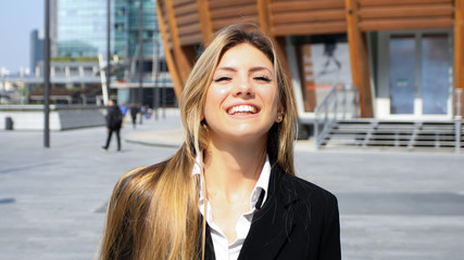 Confident young female manager walking outdoor in a modern urban setting