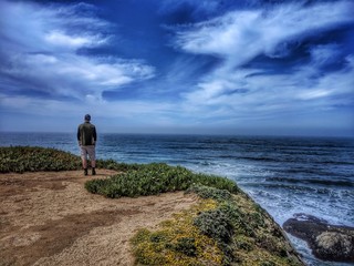 Man gazing at ocean from Cliff's edge