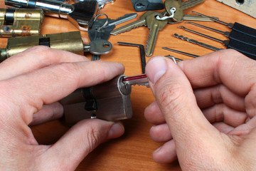 Fototapeta premium Locksmith inserts key in cylinder lock