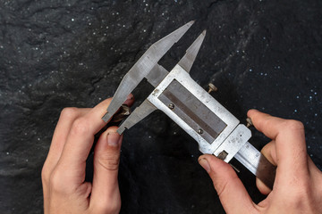 Measuring tool. Vernier caliper on black stone. Background, texture. Close-up