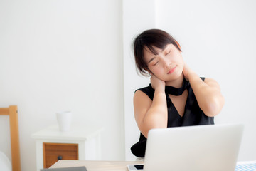 Business woman overwork on laptop computer and neck pain with at work in office, girl stress and illness chronic with office syndrome, health and emotion concept.