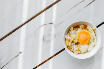 cheese and potato eggs in a bowl.  fried potatoes with fried eggs, rustic breakfast