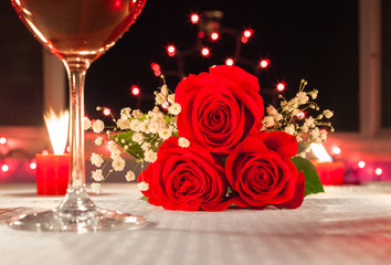 closeup of red roses in a candle light dinner setting. . Beautiful romantic fine dinning setting. 