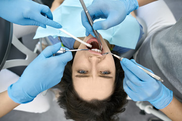 Pretty woman's teeth treatment in dental clinic