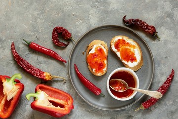 chili jam from chili pepper and paprika. fried toasts, soft (goat) cheese and chili jam. hot jam warming. copy space. top view