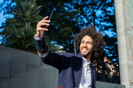 young afro american man smiling happy taking selfie self portrait picture with mobile phone