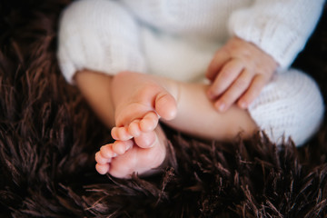 Newborn baby infant asleep, close-up of tiny little hand and foot in macro detail