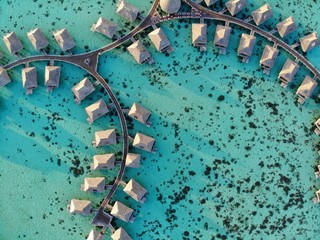 MOOREA, FRENCH POLYNESIA -30 NOV 2018- Aerial view of overwater bungalow villas with thatched roofs...