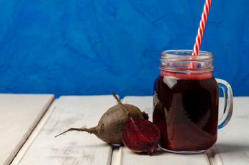 Healthy beetroot smoothie in a jar on white wooden background