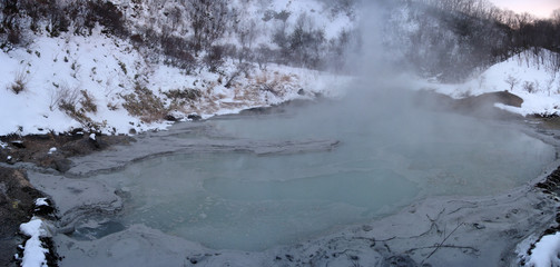 Volcanic lake, steam rising from thermal water, Jigokudani hell valley winter volcanic landscape panorama, Noboribetsu famous place