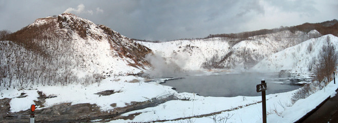 Hiking trail near Volcanic lake, steam rising from thermal water, volcano with rising smoke,...