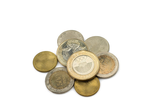 A close up image of a pile of coins from Colombia isolated in macro on a white background