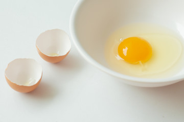 Fresh raw egg in bowl on white background.