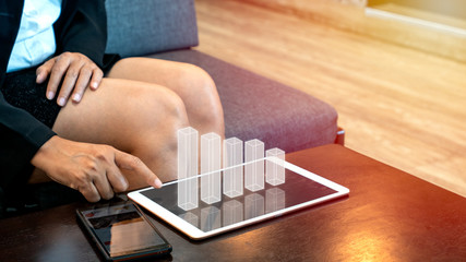 Obraz premium Business woman using digital tablet computer to analyze growing 3D BAR chart floating above screen, showing successful increase in business income profit.