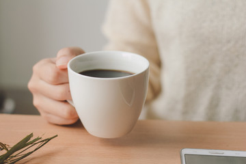 Woman holding a cup of coffee in her hands. 