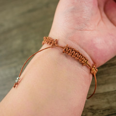 Women hand wear brown cord bracelet 