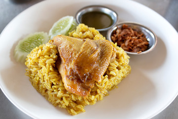 Yellow rice with chicken. Chicken Biryani with sauce. Chicken with rice mixed with spices and herbs. Halal food.