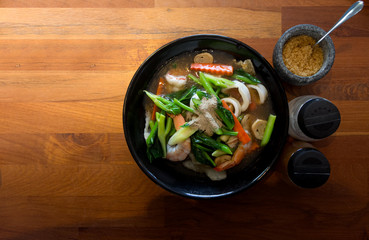 Noodles topped with seafood .