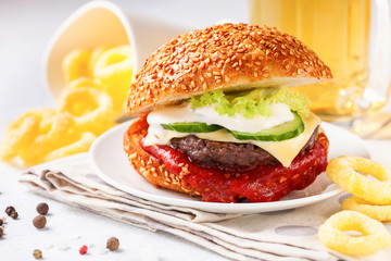 Cheeseburger on a plate and beer. Break. Snack. Selective focus. Copy space