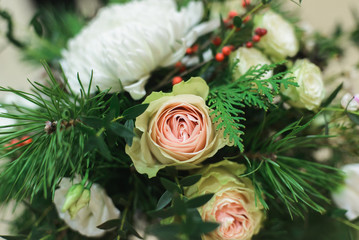 close up winter bridal bouquet with white bush roses, chrysanthemum, pine, thuja, ilex, pistachio, side view of horizontal stock photo image