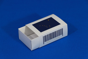 Alaska flag on white box with barcode and the color of state flag on blue background, paper packaging for put match or products.
